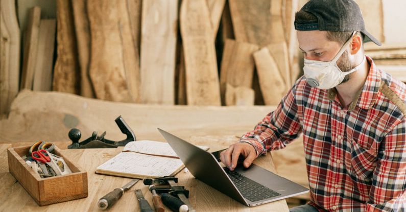 Laptop Tools - Man Using a Laptop at a Wood Workshop