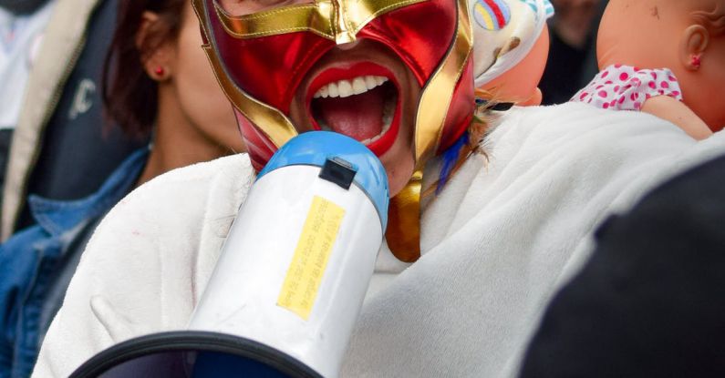 Megaphone Chart - A woman wearing a mask and holding a megaphone