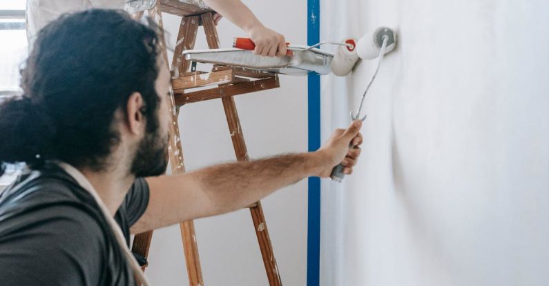 Ladder Success - A Couple Painting The Wall