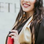 Graduation Cap - Selective Focus Photo of Smiling Woman in Black Academic Dress Holding Diploma Posing