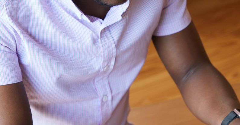 Career Choice - From above of pensive African American programmer checking settings of netbook while sitting at table