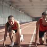 Transferable Skills - Men and Woman in Red Tank Top is Ready to Run on Track Field