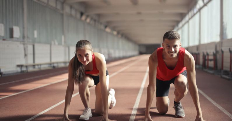 Transferable Skills - Men and Woman in Red Tank Top is Ready to Run on Track Field