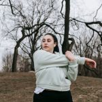 Action Verbs - Overweight young woman training in autumn park