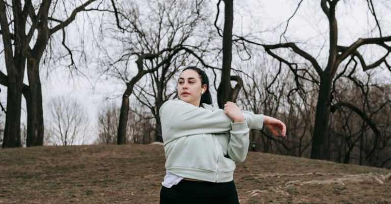 Action Verbs - Overweight young woman training in autumn park