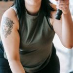 Tough Questions - Low angle of concentrated female in sportswear exercising with heavy battle ropes during intense functional training