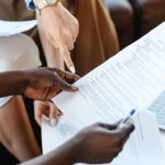 Company Research - Multiethnic businesswomen checking information in documents