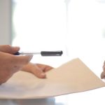 Mock Interview - Crop businessman giving contract to woman to sign