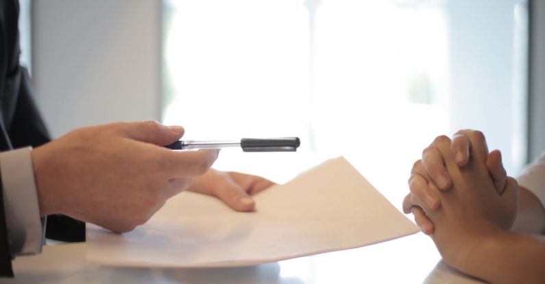 Mock Interview - Crop businessman giving contract to woman to sign