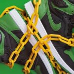Cultural Fit - Stylish sporty boots chained on green surface