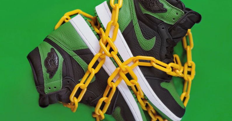 Cultural Fit - Stylish sporty boots chained on green surface