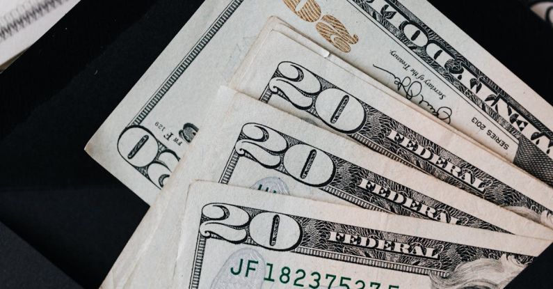 Money Growth - Stack of dollars and black envelope with banknotes inside