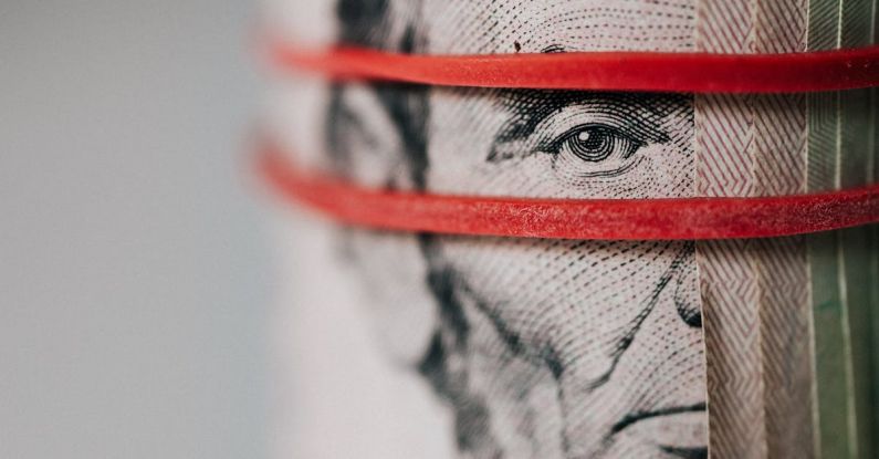 Cash Stack - Closeup of rolled United States five dollar bills tightened with red rubber band